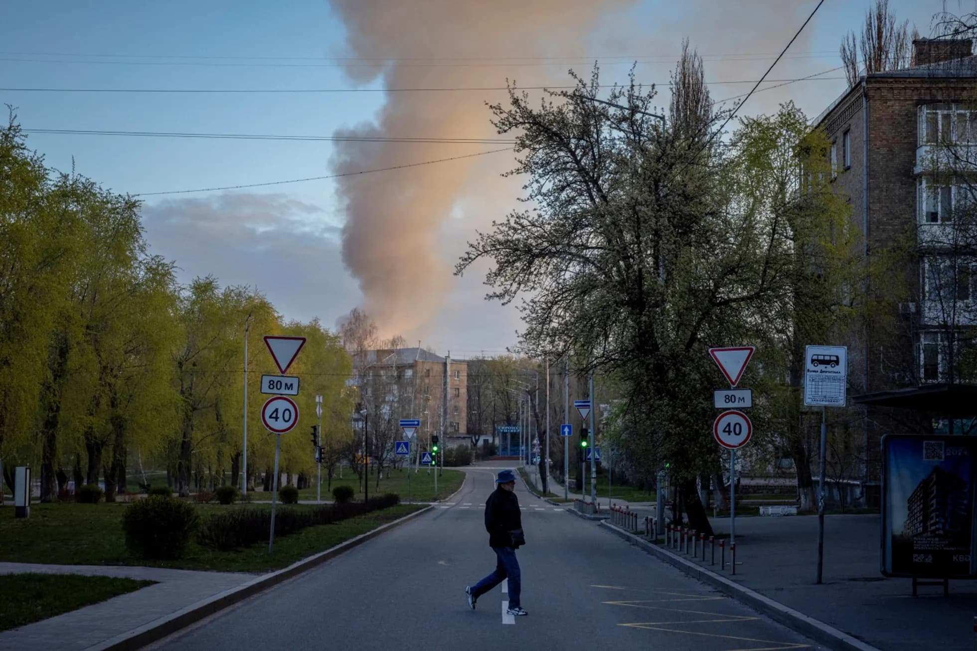 Фотографія з Києва після російської атаки. На передньому плані — пішохід та київські дорожні знаки.